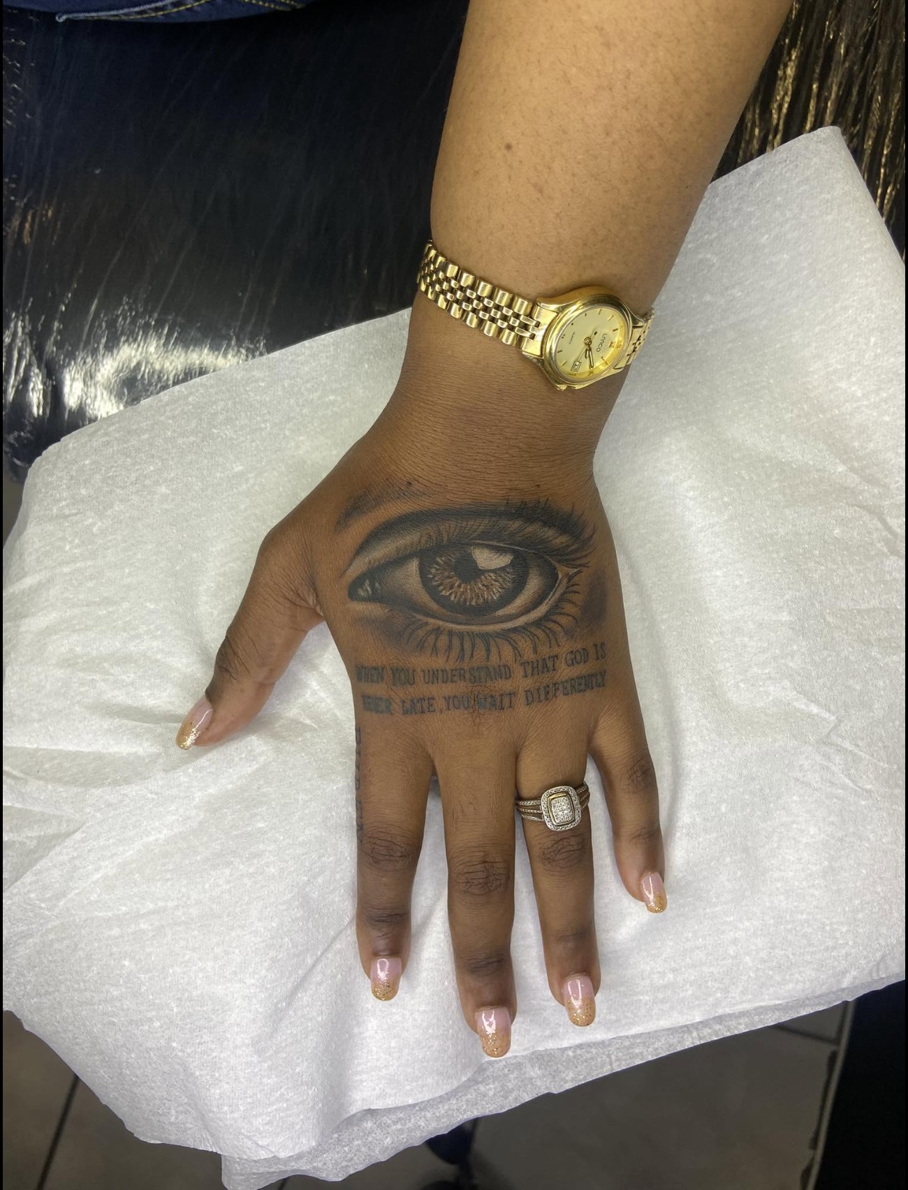 Realism eye tattoo on the hand with scripture lettering — by Professional Black Ink